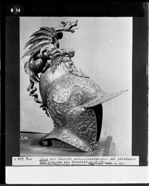 Helm mit reicher Metalltreibarbeit und geflügeltem Drachen als Helmzier