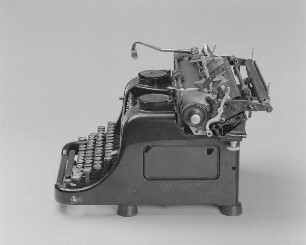 Typenhebelschreibmaschine "Rheinmetall". Vorderanschlag (sofort sichtbare Schrift), Universaltastatur, Farbband. Seitenansicht von rechts oben