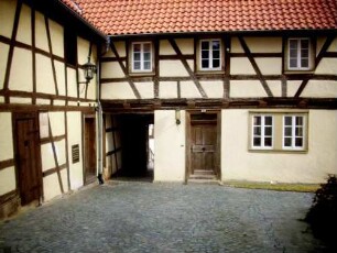 Kirchhof im Nordosten mit Fachwerkhäusern (einst Gaden-Kirchenburg mit Kirchhofmauer als Außenmauer der Gaden)-teilrekonstruiert 20 Jh auf alter Grundlage
