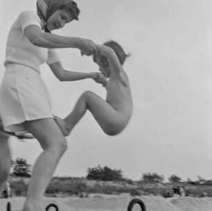 Elisabeth Gremmler spielt am Strand mit einem Kind, um 1938