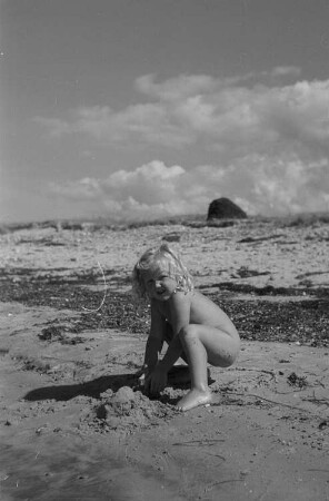 Hiddensee: Kinder beim Baden, Landschaften, Meeresaufnahmen : Kleines Mädchen am Strand, mit Sand spielend