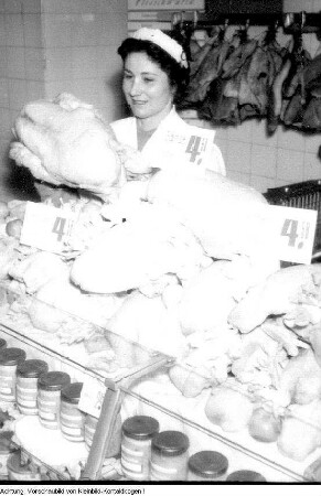 Dresden. Konsum, Verkaufsstelle. Verkäuferin hinter einer Kühltheke mit Geflügel, Dezember? 1956