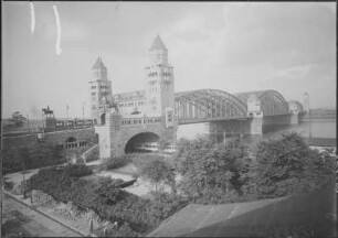 Köln, Hohenzollernbrücke : Köln. Hohenzollernbrücke. Eisenbahn- und Straßenbrücke über den Rhein. Schrägansicht (oberstrom) vom linken Ufer