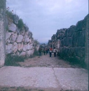 Tiryns. Touristen an Resten der Zyklopen-Mauer bei Tiryns