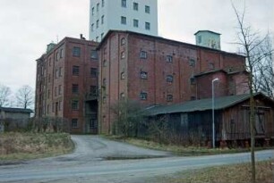 Lasbek-Barkhorst: Mühlenweg 3: Barkhorster Mühle W. F. Stoltenberg: links Mühlengebäude aus Backstein: davor altes Silogebäude aus Backstein: vorne rechts Bahn-Verladeschuppen der Mühle: im Hintergrund modernes Silo: von vorne Auffahrt auf Betriebsgelände, links altes Wachhäuschen: 26. Januar 1999