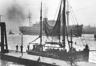 Hamburg. Ein japanischer Dampfer verlässt den Hafen. Im Vordergrund der Fischereihafen mit einem Fischkutter am Kai. Aufgenommen 1935