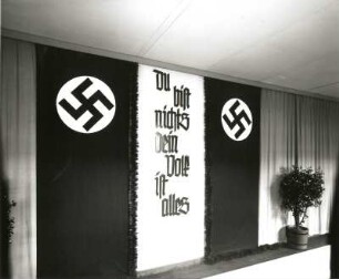 Nassau/Erzgebirge, Schule, Inneres, Flur, Wandschmuck, von Hakenkreuzen und Kübelpflanzen flankierte nationalsozialistische Propaganda "Du bist nichts - Dein Volk ist alles"