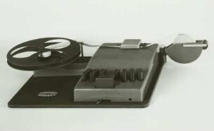 Mechanische Blindenschrift-Stenografiermaschine mit 7 Tasten zum Anschlagen der Punkte, Zwischenraumtaste und Streifenschreiber. Schrägansicht von vorn : Mechanische Blindenschrift-Stenografiermaschine mit 7 Tasten zum Anschlagen der Punkte, Zwischenraumtaste und Streifenschreiber. Schrägansicht von vorn. Baujahr: 1950/1955; Hersteller: Firma Karl Neubert . Verwalter: Sächsische Landesbibliothek - Staats- und Universitätsbibliothek Dresden (SLUB), Stenografische Sammlung, Inventar-Nummer R i 0027