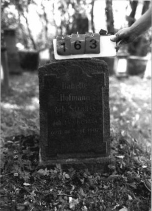 Grabstein 163 (Index: 100110664) Material: Granit, Schriftfeld poliert Zustand: gut Maße HxBxT: 71x42x10 cm Beschreibung: Stele, Sockel, Segmentbogenabschluß, Schriftfeld erhaben mit überstehenden Ecken und eingezogenem Rundbogen: Grabstein 163