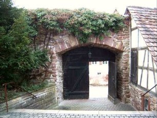 Kirchhof im Westen mit Kirchhofmauer und erhaltenem äußern Torbogen (Kammertor sowie Wehrgang mit Steinbrüstung im 18 Jh abgetragen)-im Norden erneuerter Fachwerk-Gaden