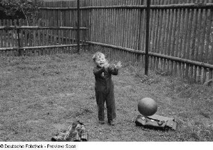 Kleiner Junge, mit einem Ball spielend