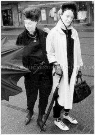 Zwei individuell gekleidete junge Frauen mit verfremdeten Gesichtern (Sonderthema: Kleider machen Leute)