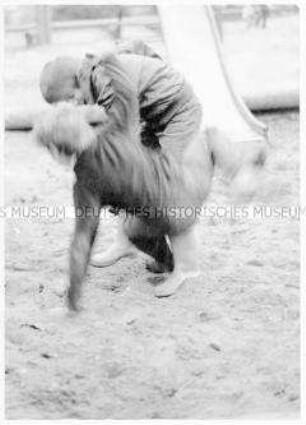 Zwei Jungen balgen auf einem Spielplatz (Altersgruppe 14-17)