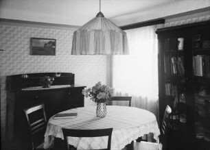 Coswig, Hohe Straße 9. Mehrfamilienhaus (Sechsfamilienhaus) (1928/1929). Wohnzimmerecke mit Eßtisch, Anrichte und Bücherschrank