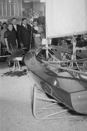 Mehrere Personen betrachten ein auf der Leipziger Herbstmesse 1955 ausgestelltes Segelboot