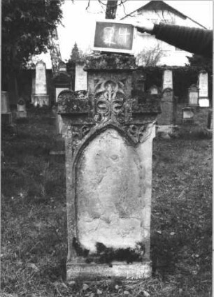 Grabstein 24 (Index: 100112305) Material: Sandstein Zustand: beschädigt und verwittert Maße HxBxT: 145x52x16 cm Beschreibung: Stele, Sockel, getreppter Abschluß, Schriftfeld eingetieft mit Spitzbogenabschluß Symbolik: Maßwerk: Grabstein 24