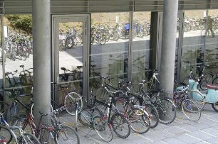 Fahrräder und ein Moped vor dem Haupteingang