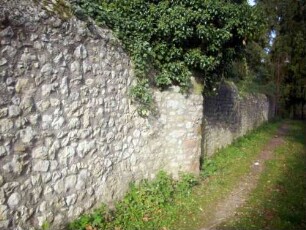 Kirchhofmauer im Westen (Wehrgang mit Steinbrüstung abgetragen) mit Ansatz eines ehemaligen Flankierungsturmes sowie Werksteinen im Mauersteinverband