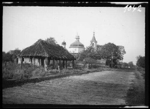 Kamien Koszyrski (=Kamin-Kaschyrskyj, Ukraine): Breiter Bohlenweg mit Kirche der Heiligen Gottesmutter] im Hintergrund