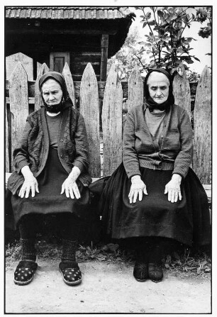 Maramures. Zwei alte Frauen sitzen vor einem Zaun