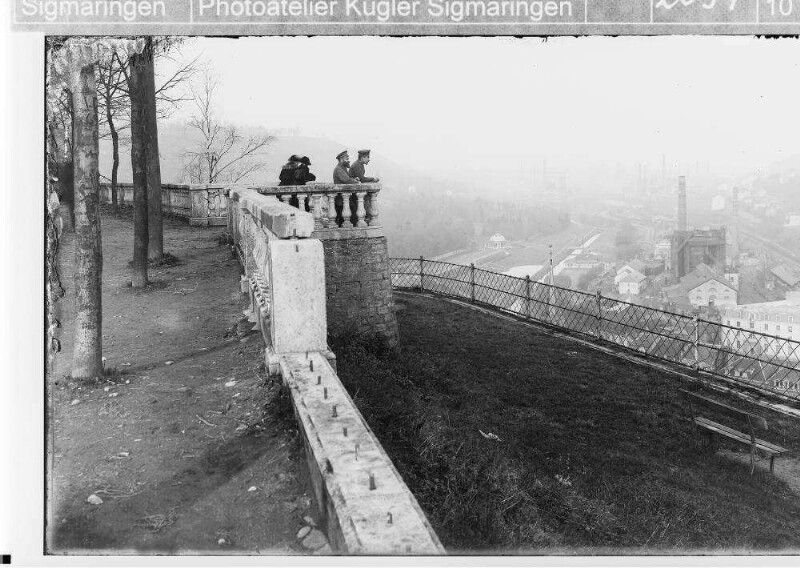 Zwei deutsche Soldaten und zwei Frauen bei einem Aussichtspunkt mit Blick auf eine Industrieanlage in Longwy