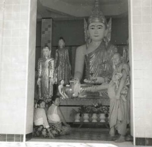 Myanmar (Burma), Rangoon (Rangun). Shwe-Dagon-Pagode (14. Jahrhundert). Gläubige vor Buddha-Statue