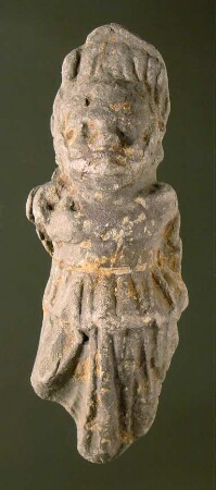 Karikierte langbekleidete (weibliche?) Figur, hinten abgeflacht