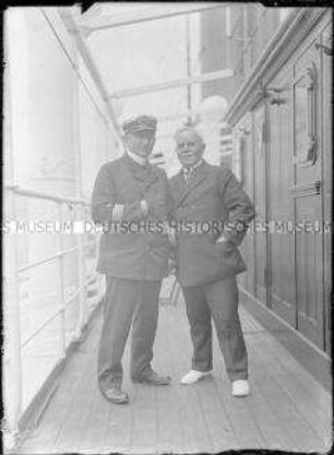 Zwei Herren an Bord des Hochseepassagierdampfers "Bremen", linke Person in Uniform des Norddeutschen Lloyd