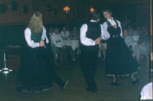 Norwegische Folkloregruppe mit Tanzpaaren und Akkordeonspieler