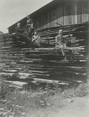 Elisabeth und Rudolf Kroll auf dem Lande mit Freunden auf einem Bretterstapel sitzend