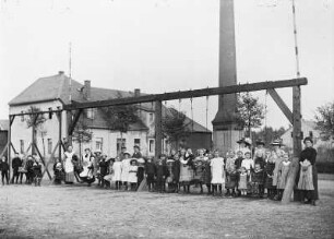 Kinder (wohl der Mitarbeiter der Lederfabrik) mit Betreuerinnen an einem Schaukelgestell. Gruppenaufnahme. Freiberg-Zug, Lederfabrik Zug, Werkteil Zugspitze