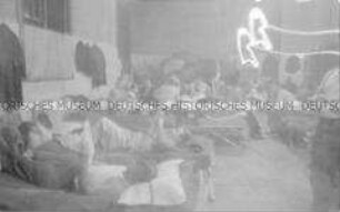 Selbstversenkung des Hochseepassagierdampfers "Columbus" am 19. Dezember 1939, Besatzungsangehörige im Internierungslager auf Ellis Island, in einfachen Feldbetten liegend, Zeitung lesend