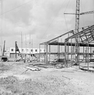 Gewerbegebiet Reinbek/Glinde/Schönningstedt: Bau eines Gewerbebetriebes: Errichtung der Stahlkonstruktion: rechts Baukran: hinten links Baubude und Pkw: dazwischen Baumaterial und Gerüst: im Hintergrund fertige Gebäude