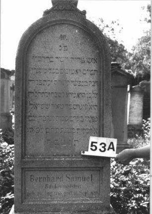 Grabstein 53 (Index: 100114354) Material: Kalkstein Zustand: leicht verwittert Maße HxBxT: 183x64x31 cm Beschreibung: Stele, getreppter Sockel, Rundbogenabschluß mit Mittelakroter Symbolik: Palmette und Voluten als Mittelakroter: Grabstein 53A