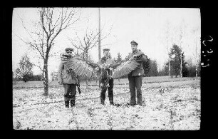 bei Bialowiesk (?) (=Bia³owie¿a, Polen): 2 Offiziere mit Schirmmütze, 1 Soldat mit Feldmütze mit einem an den Flügeln auseinandergehaltenen "erlegten Seeadler"