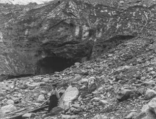 Berghang : Ein felsiger Berghang in den Alpen mit einer Höhle im Hintergrund