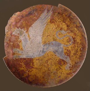 Deckel eines griechischen Klappspiegels mit Frauenkopf in Vorderansicht und Darstellung eines Greifen auf der Unterseite
