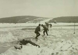 Eis auf dem Kleinen Galgenteich bei Altenberg : Eine Scholle wird mit Eishaken aus dem Wasser gezogen