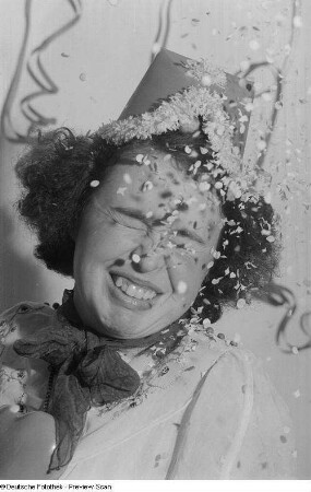 Portrait einer kostümierten Frau im Konfettiregen