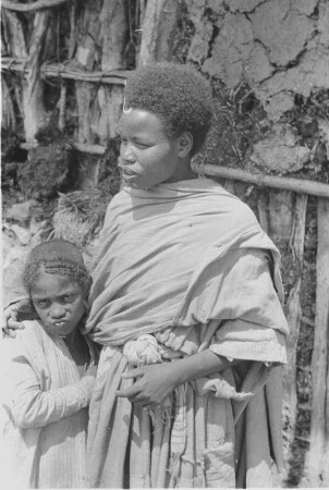 Frau der Amhara : Junge Amhara-Frau vor ihrer Hütte. Im Arm ein junges Mädchen