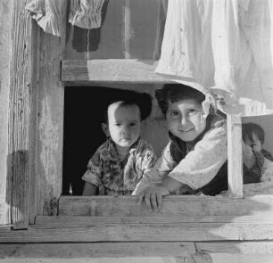 Romadorf, zwei Kinder schauen aus einem Fenster