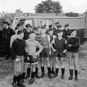 Tremsbüttel: Amtsfeuerwehrfest: Festplatz: Tremsbütteler Schülergruppe in Stiefeln und mit Feuerwehrkäppchen; dahinter Wehrführer des Amtes und des Kreisfeuerwehrverbandes vor Löschfahrzeug