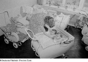 Mutter mit zwei Kleinkindern im Kinderwagen in der Mütterberatung