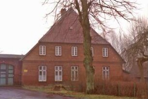 Dorfstraße (54): Bauernhaus aus Backstein: Giebelseite Wohntrakt: links an Traufseite Anbau mit Tor: vorne Zufahrt, Vorgarten, Baum