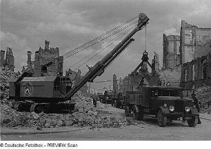 Dresden. Beladen von Lastkraftwagenzügen mit Greiferbagger