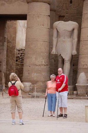 Touristen posieren im Luxor Tempel vor Pharao-Skulpturen