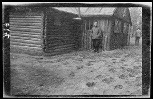 Offizier vor einem Blockhaus, davor morastiger Boden