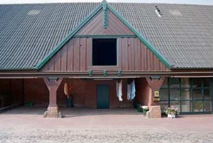 Fritz-Berodt-Straße 7-9: Hofanlage: Haus Nr. 7 [Haus am Teich]: Traufseite zum Hof, Teilansicht: ehemalige Remise mit Holzständern, darüber Frontispiz mit Verbretterung, Luke, oben Giebelzier, rechts moderner Eingangsbereich mit Verglasung: 21. Oktober 1993