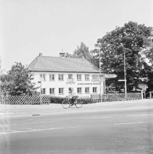 Gemeindeverwaltung: Möllner Landstraße: altes Rathaus: davor Jägerzaun und Straßenschilder: davor Fahrradfahrer auf Radweg: links und rechts Bäume