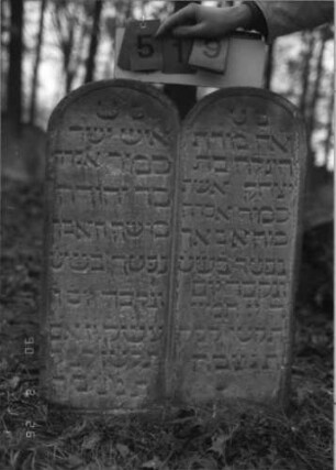 Grabstein 519 (Index: 100115444) Material: Sandstein Zustand: verwittert Maße HxBxT: 79x71x10 cm Beschreibung: Doppelstele mit doppeltem Rundbogen, eingetieftes Schriftfeld Besonderheit: Doppelgrab für Eheleute: Grabstein 519